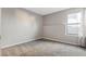Neutral bedroom has newer carpet, clean white trim, and a nice window for natural light at 14046 E Stanford Cir # I04, Aurora, CO 80015