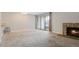Carpeted living room with a stone fireplace and sliding glass doors to the exterior at 14046 E Stanford Cir # I04, Aurora, CO 80015