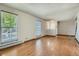 Open concept living room with hardwood floors, large windows, and neutral paint at 4351 E 109Th Ave, Thornton, CO 80233