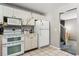 Well-lit kitchen featuring white appliances, ample counter space, and tiled flooring for easy maintenance at 9375 W David Ave, Littleton, CO 80128