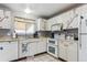 Efficient kitchen with white cabinets, tile floors, and modern appliances, perfect for cooking at 9375 W David Ave, Littleton, CO 80128