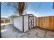 Backyard shed with a unique X-shaped door and a stone pathway, next to privacy fence at 832 Dahlia St, Denver, CO 80220