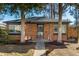 Charming red brick home with mature trees and a well-manicured lawn at 832 Dahlia St, Denver, CO 80220