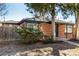 Quaint brick home featuring a well-maintained yard and mature landscaping at 832 Dahlia St, Denver, CO 80220
