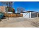 Garage in backyard with paved area, gray door and privacy fence at 832 Dahlia St, Denver, CO 80220