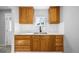 Bright kitchen with white backsplash, stainless steel sink, light countertops and wood cabinets at 832 Dahlia St, Denver, CO 80220