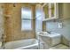 The bathroom features a tub with tile surround, white vanity and cabinet, and window at 504 Martin St, Longmont, CO 80501