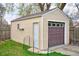 Detached one-car garage with a new door and a fenced-in area adjacent to the building at 504 Martin St, Longmont, CO 80501