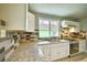 Bright kitchen showcasing granite countertops, stainless steel appliances, and a window overlooking the backyard at 504 Martin St, Longmont, CO 80501