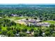 Scenic aerial shot of a lush green neighborhood with a school and glimpses of the city skyline at 9656 Rensselaer Dr, Arvada, CO 80004