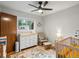 Cozy Bedroom with a white dresser, rocking chair, crib, and an area rug at 9656 Rensselaer Dr, Arvada, CO 80004