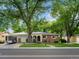 Charming single-story brick home with a well-manicured lawn and mature trees at 9656 Rensselaer Dr, Arvada, CO 80004