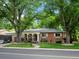 Inviting brick home with unique arched entryway, lush lawn, and mature trees for a welcoming curb appeal at 9656 Rensselaer Dr, Arvada, CO 80004