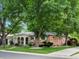 Attractive single-story brick home featuring a welcoming front porch, trimmed bushes, and tree accents at 9656 Rensselaer Dr, Arvada, CO 80004