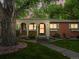 Charming front porch with brick accents and a well-maintained lawn and mature trees at 9656 Rensselaer Dr, Arvada, CO 80004