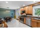 Open kitchen with wooden cabinets, stainless steel appliances, and an adjacent dining area at 9656 Rensselaer Dr, Arvada, CO 80004