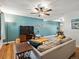 Bright living room features modern furnishings, a ceiling fan, and a large television on a wooden stand at 9656 Rensselaer Dr, Arvada, CO 80004