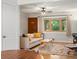 Open living room features a large window, hardwood floors, and neutral colored walls and contemporary furniture at 9656 Rensselaer Dr, Arvada, CO 80004