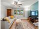 Inviting living room featuring hardwood floors, large bay window, and modern decor open to dining area at 9656 Rensselaer Dr, Arvada, CO 80004