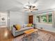 Cozy living room featuring hardwood floors, a large window with natural light, and modern decor at 9656 Rensselaer Dr, Arvada, CO 80004