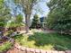 Spacious backyard featuring lush lawn, mature trees, and a covered patio area at 4049 S Quatar St, Aurora, CO 80018