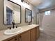 Bathroom with double sinks, decorative mirrors, and a shower-tub combo at 4049 S Quatar St, Aurora, CO 80018