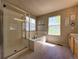 Bright bathroom features a tiled shower, a soaking tub, and double windows at 4049 S Quatar St, Aurora, CO 80018