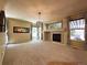 Inviting living room with a cozy fireplace, large windows, and neutral carpeting throughout at 4049 S Quatar St, Aurora, CO 80018