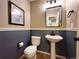 Stylish powder room with a pedestal sink, wainscoting, and elegant fixtures at 4049 S Quatar St, Aurora, CO 80018
