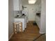 Compact kitchen featuring white cabinets, appliances, and a breakfast bar stool at 2201 Sable Blvd # 1007, Aurora, CO 80011
