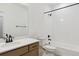 Clean bathroom featuring a wooden vanity, toilet and a shower over bath with white tiling at 39202 Clymer St, Elizabeth, CO 80107