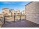 A private balcony with wood floors and metal railing overlooks the neighborhood at 7928 E 54Th Pl, Denver, CO 80238