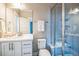 Modern bathroom with a glass-enclosed shower, white vanity, and large mirror at 7928 E 54Th Pl, Denver, CO 80238