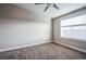 A carpeted bedroom features a ceiling fan, a window, and neutral paint colors at 7928 E 54Th Pl, Denver, CO 80238