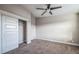 A bright bedroom with closet and ceiling fan boasts cozy gray carpeting at 7928 E 54Th Pl, Denver, CO 80238