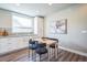 Cozy dining area with natural wood table and modern black chairs, adjacent to a kitchen with ample natural light at 7928 E 54Th Pl, Denver, CO 80238