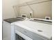 A functional laundry area features a white washer and dryer with wire shelving at 7928 E 54Th Pl, Denver, CO 80238