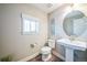 Stylish powder room featuring a pedestal sink, modern fixtures, and a window for natural light at 7928 E 54Th Pl, Denver, CO 80238