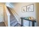 Stylish staircase features neutral carpet, modern art, and a sleek console table with elegant decor at 7928 E 54Th Pl, Denver, CO 80238