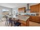 Bright kitchen with wood cabinets, granite countertops, and an island with seating at 616 Scrubjay Cir, Castle Rock, CO 80104