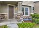 Close-up of a townhome porch with stone pillars, a brown door, and manicured landscaping at 2356 W 165Th Pl, Broomfield, CO 80023