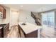 Open kitchen with a center island with sink, stainless appliances, and an open floor plan to the living room and stairs at 2356 W 165Th Pl, Broomfield, CO 80023
