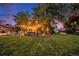 Backyard with string lights, mature trees, green grass, and an outdoor entertainment area for entertaining guests at 8691 Bluebunch Ct, Parker, CO 80134