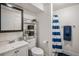 Bright bathroom featuring a standup shower, shelf storage, and a single sink vanity at 8691 Bluebunch Ct, Parker, CO 80134