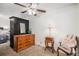 Bright bedroom features a dresser, wardrobe, ceiling fan, and a faux fur chair at 8691 Bluebunch Ct, Parker, CO 80134