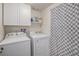 Well-equipped laundry room with modern washer and dryer, and storage at 8691 Bluebunch Ct, Parker, CO 80134