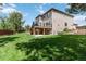 Expansive backyard features a well-maintained lawn and a lovely deck with stairs to the yard at 9169 Fox Fire Way, Highlands Ranch, CO 80129