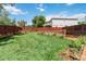 Beautifully landscaped backyard with a lush lawn, garden beds, and a charming fence at 9169 Fox Fire Way, Highlands Ranch, CO 80129
