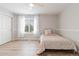 Light and airy bedroom with neutral walls, a large window, sheer curtains, and light hardwood floors at 9169 Fox Fire Way, Highlands Ranch, CO 80129