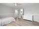 Well-lit bedroom with neutral walls, hardwood floors, a fan, and a view into the en-suite bathroom at 9169 Fox Fire Way, Highlands Ranch, CO 80129